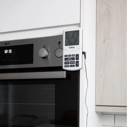 Un four Thermomètre.fr blanc auquel est fixée une horloge numérique. Le four dispose également d'un Thermomètre ChefAlarm intégré pour un contrôle précis de la température pendant la cuisson.